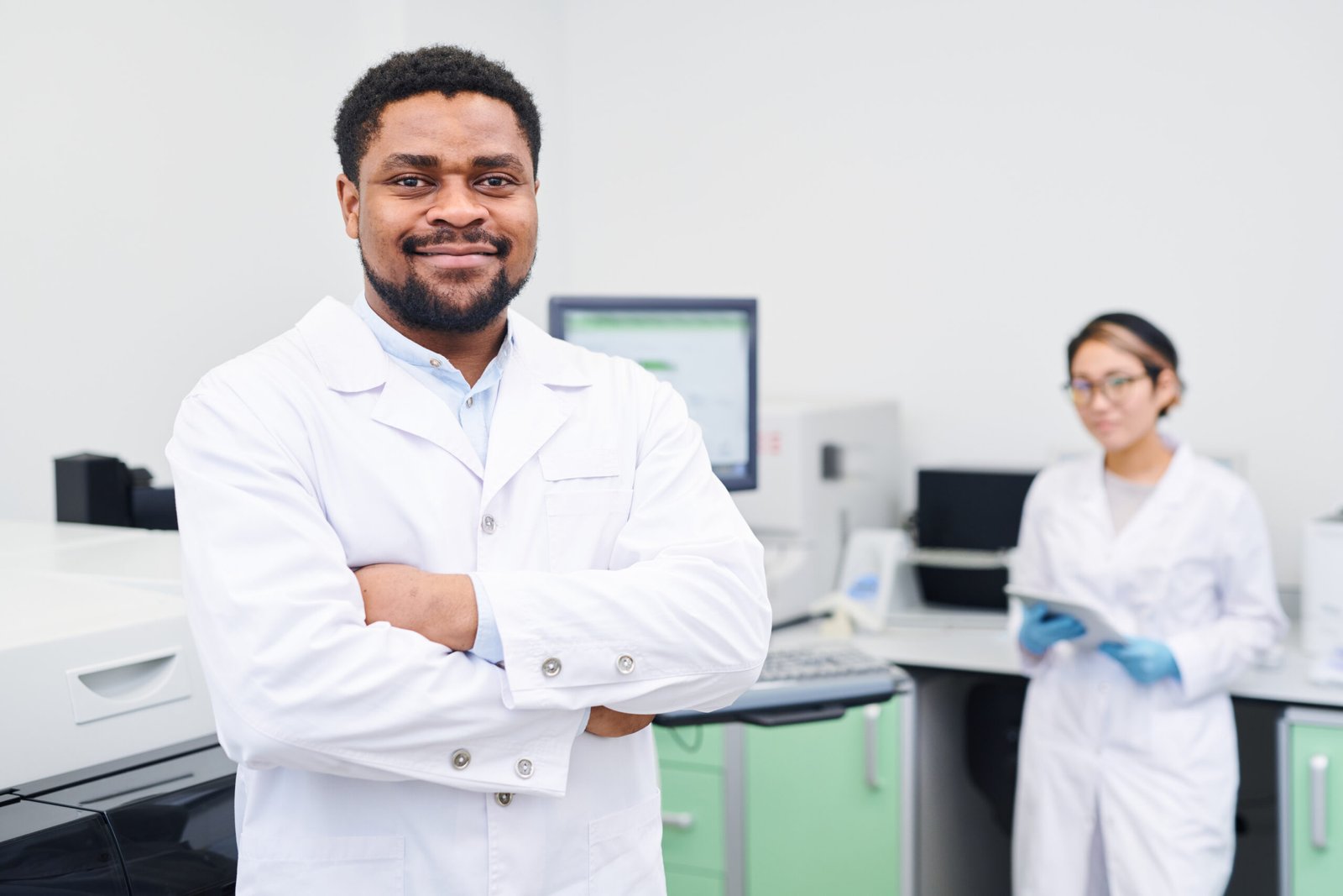 Content confident experienced handsome young African-American medical scientist with beard crossing arms on chest and looking at camera